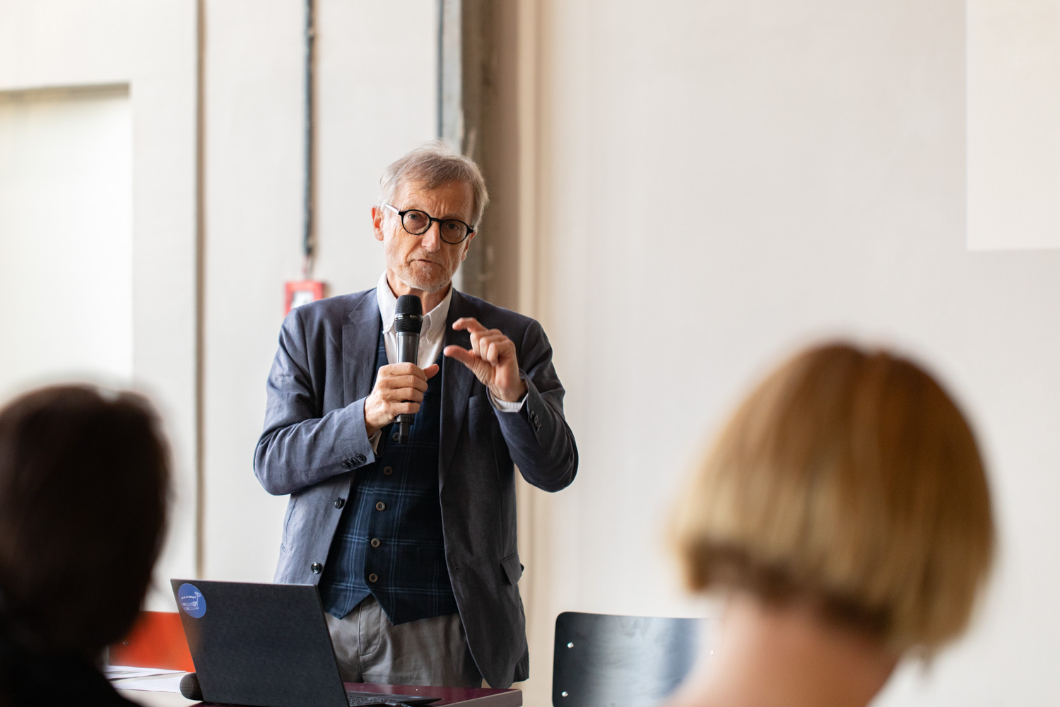 Speaker mit Mikrofon vor Publikum
